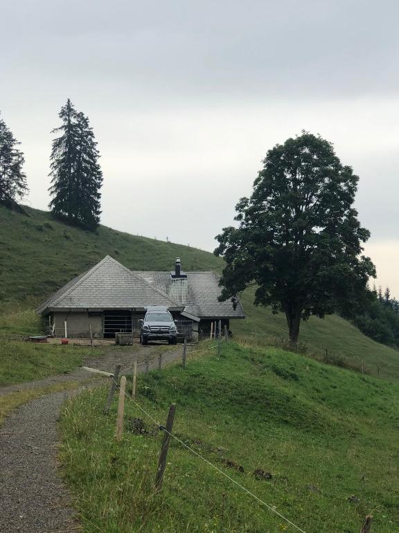 a car parked in front of a house on a hill at Staldenhaus Riggisalp in Plaffeien