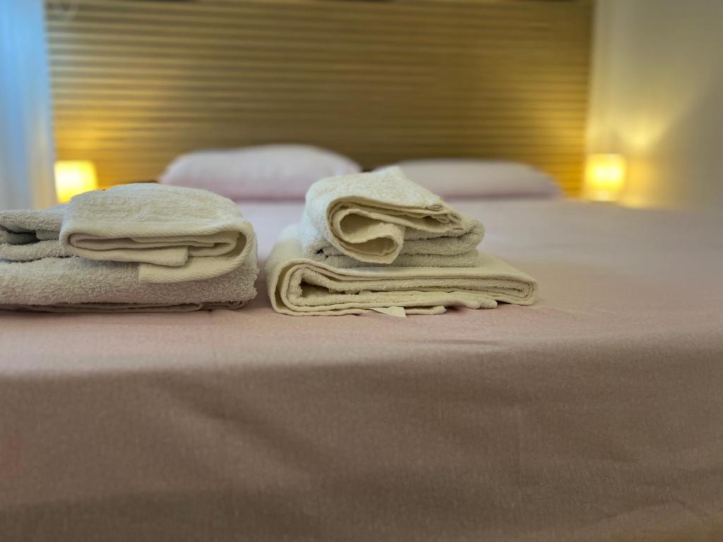 2 toallas están apiladas en la parte superior de una cama en L'angolo del Massimo Palermo, en Palermo