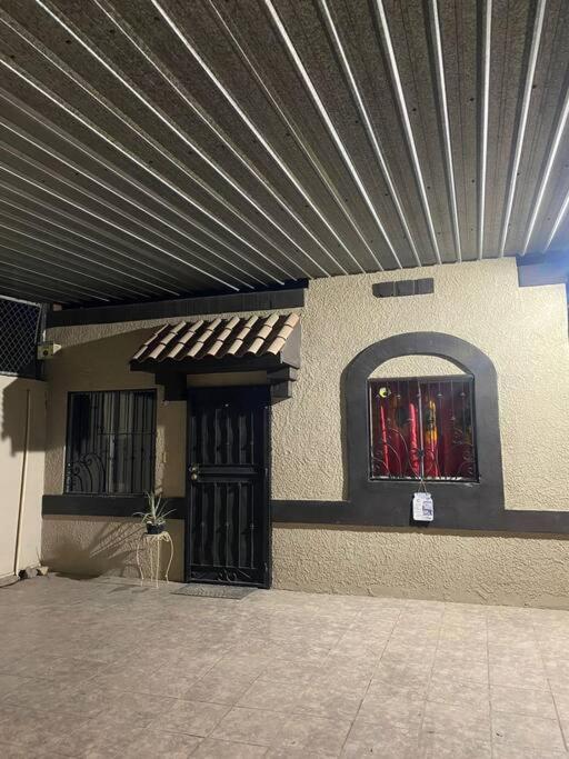 a building with a metal roof and a door with a window at casa roble in Mexicali
