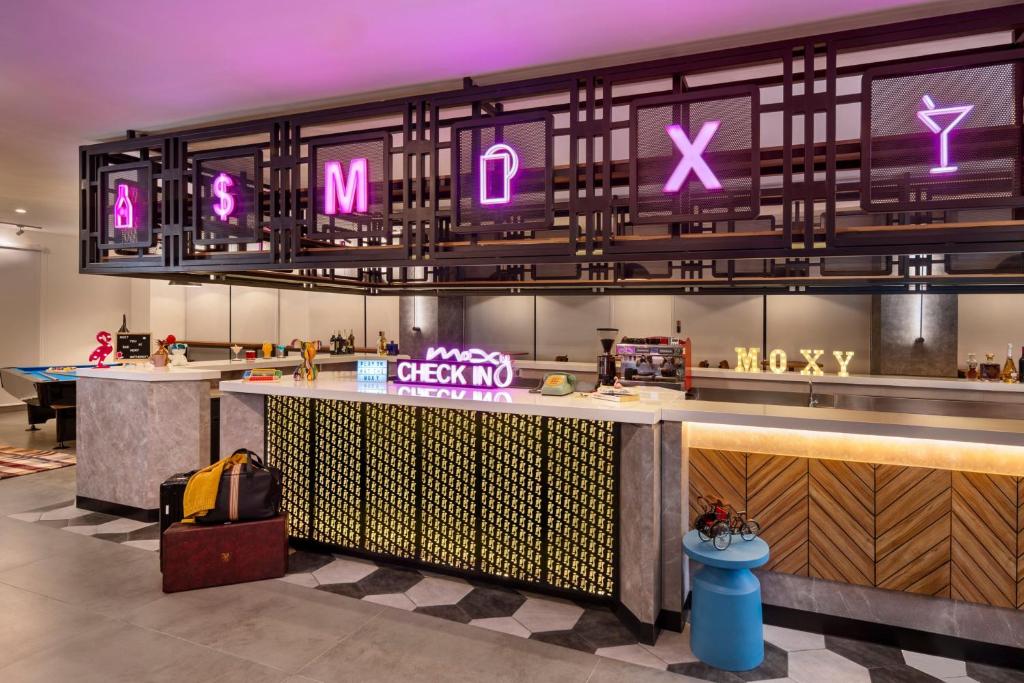 un ristorante con un bar con un cartello che dice xxx e axx di Moxy Solo a Solo