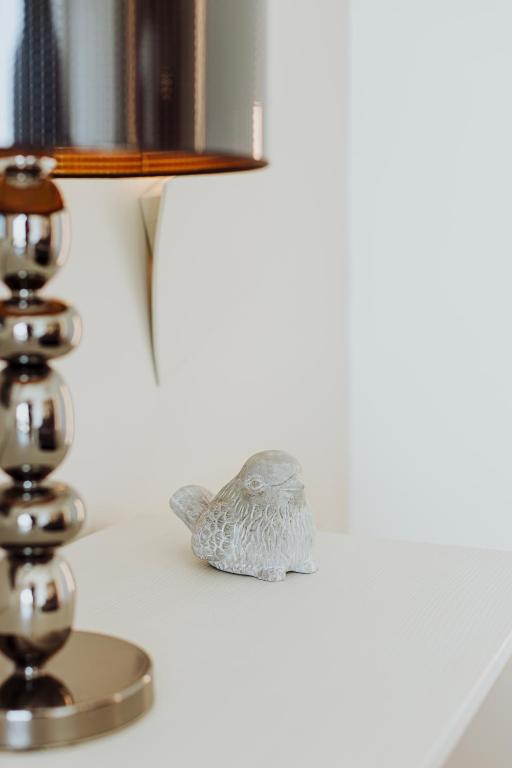 a small bird figurine sitting on a shelf next to a lamp at Suite 106 in Vasto
