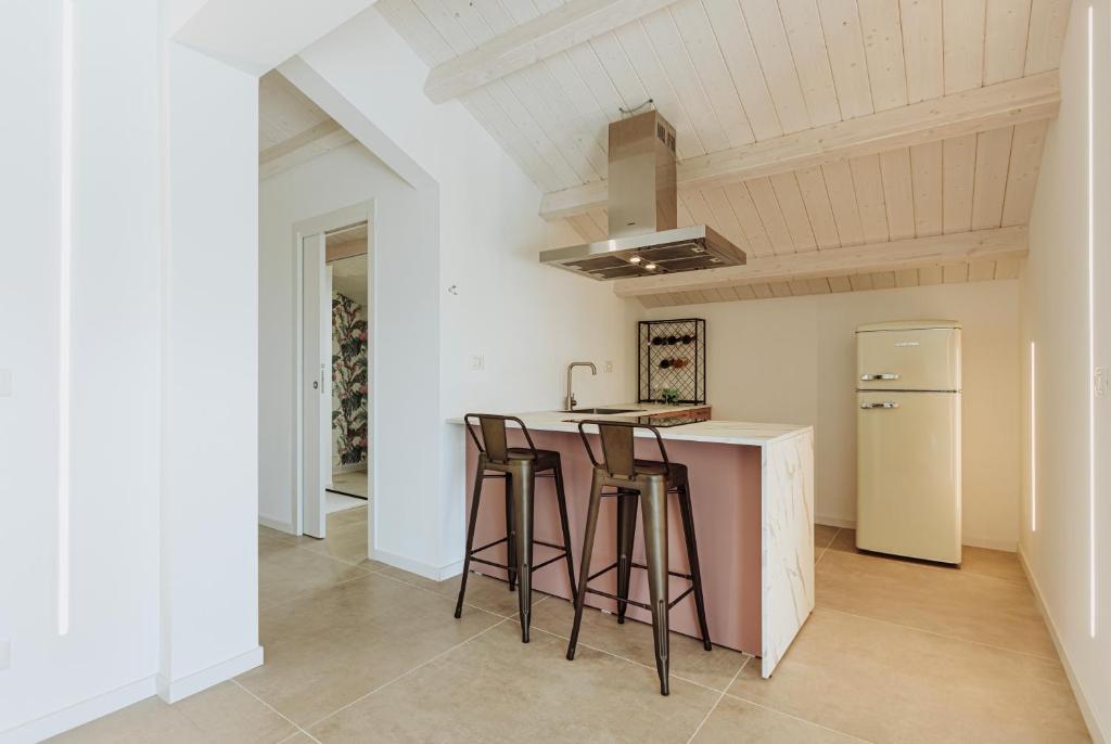 a kitchen with a counter with stools and a refrigerator at Suite 106 in Vasto