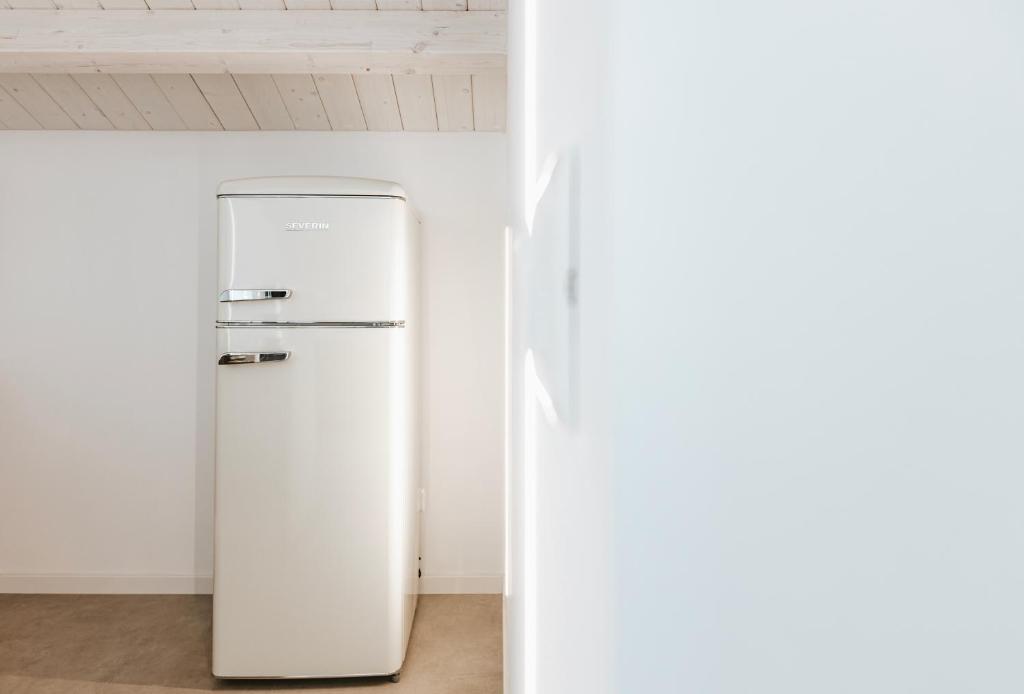 a white refrigerator in a room with a wall at Suite 106 in Vasto