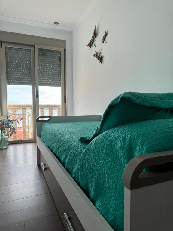 sypialnia z łóżkiem z zieloną pościelą i motylami na ścianie w obiekcie CASA LELA w mieście O Pindo