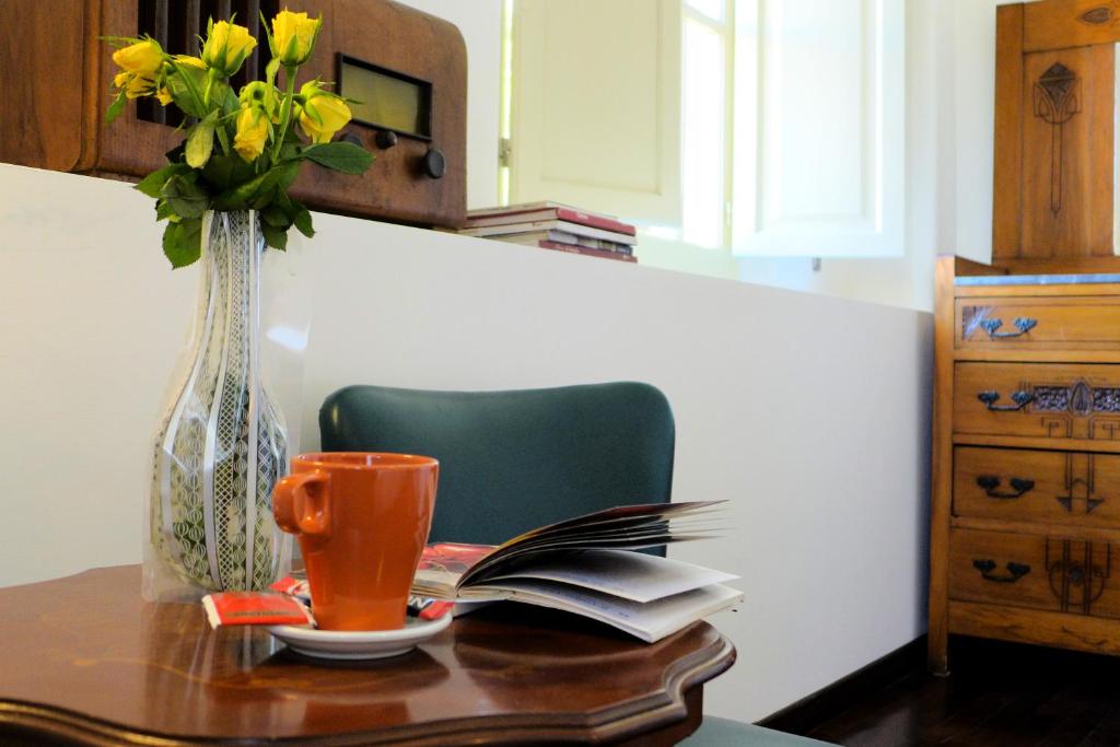 un tavolo con un vaso di fiori e un libro di Guest House Interno4 a Roma