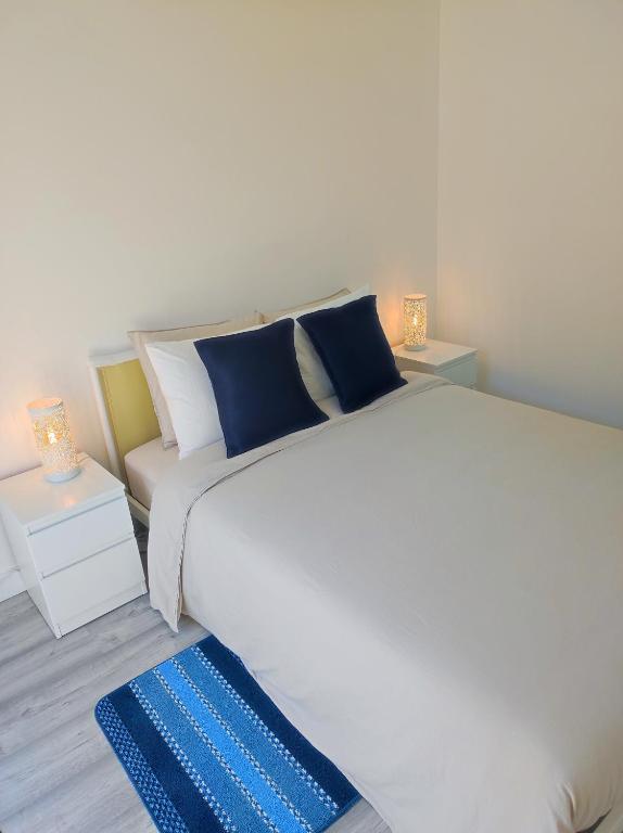 a bedroom with a large white bed and a couch at Vista Panorâmica Amadora Central in Amadora