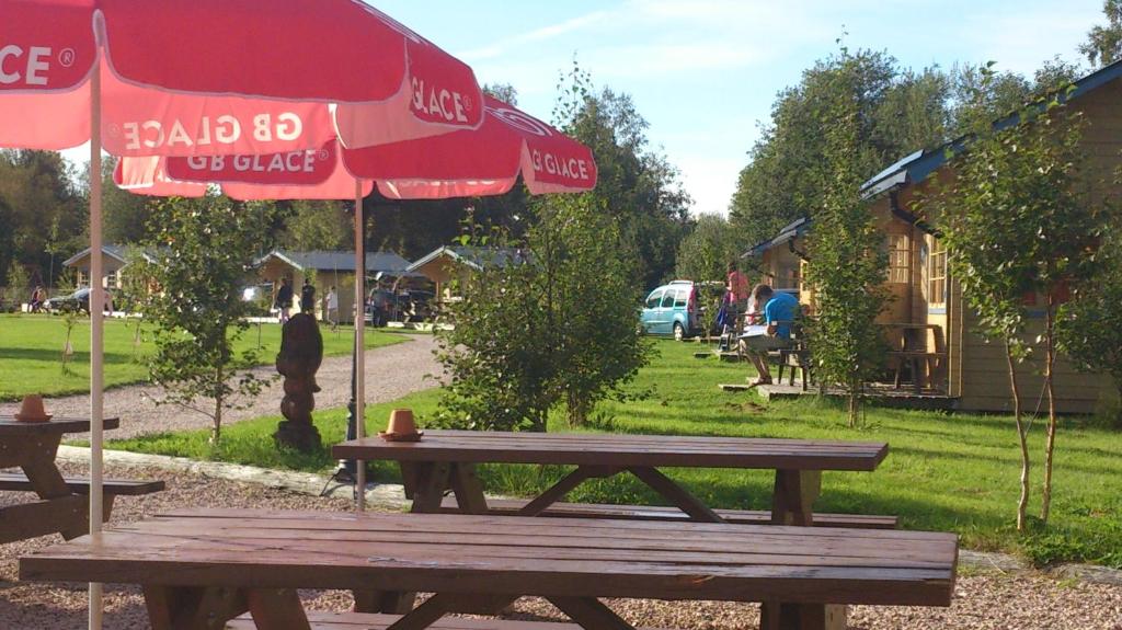 un tavolo da picnic con ombrellone rosso e picnic di Yttermalungs Camping a Bjuråker