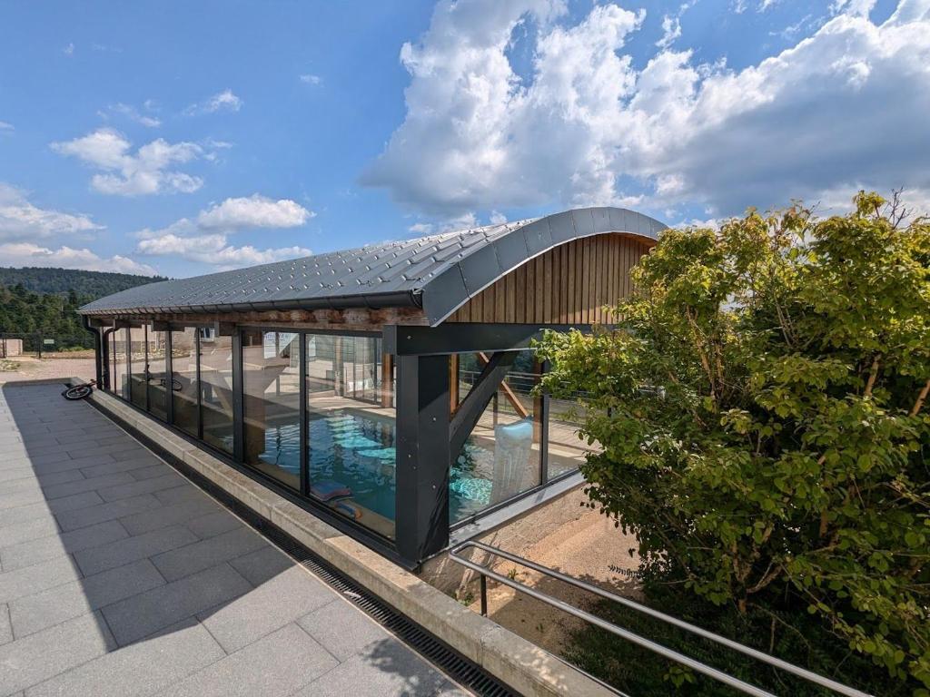 a building with a swimming pool on top of it at Gîte Montagne avec Piscine Chauffée, Spa et Sauna - Les Roches - FR-1-589-656 in Le Val-dʼAjol