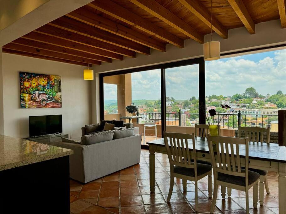 a living room with a couch and a table with chairs at Charming No Stairs Near DT Security Pool Parking in San Miguel de Allende