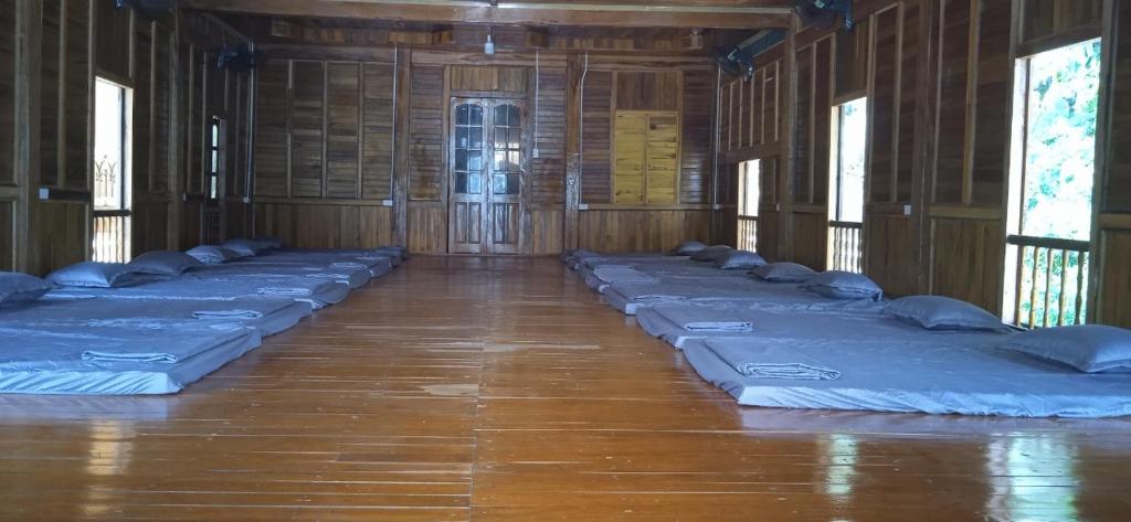 a row of blue mattresses in a room with windows at Bảo lộc homestay in Ðà Bắc
