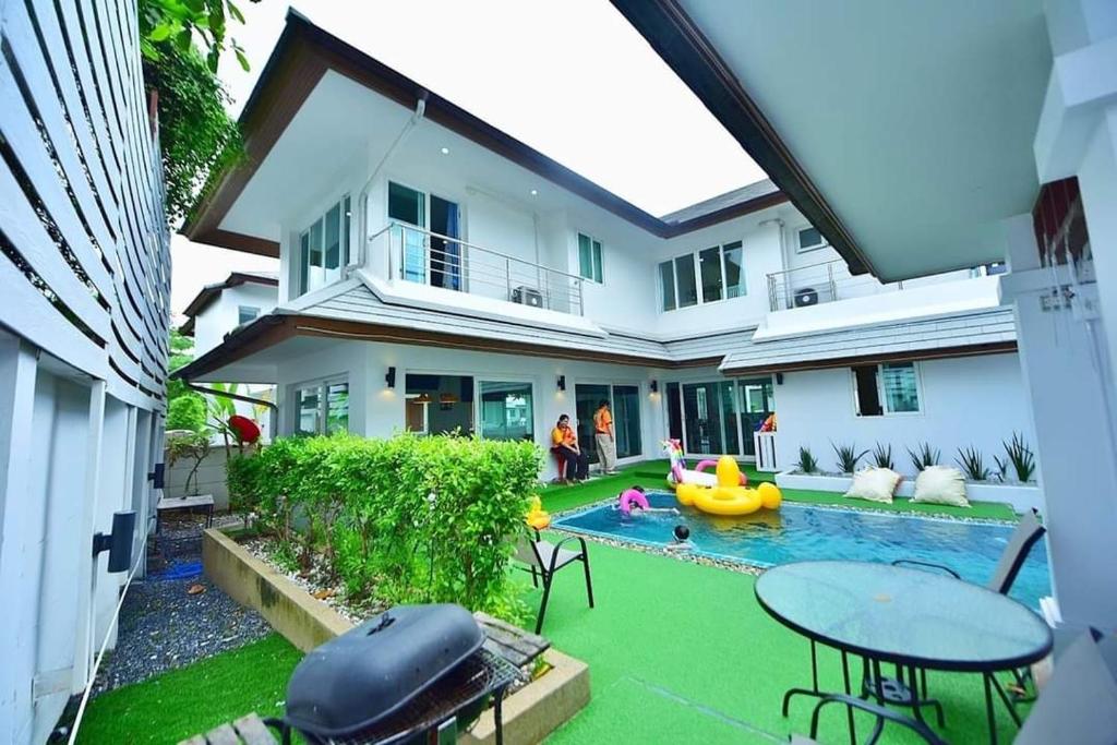 a backyard with a pool and a house at บ้านลิน พูลวิลล่า พัทยา in Bang Lamung
