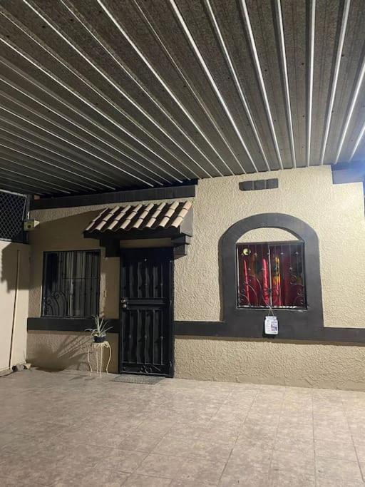 a building with a metal roof and a door with a window at casa roble in Mexicali