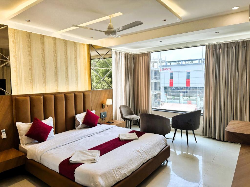 a bedroom with a large bed and a large window at Hotel Relax Inn in Bānswāra