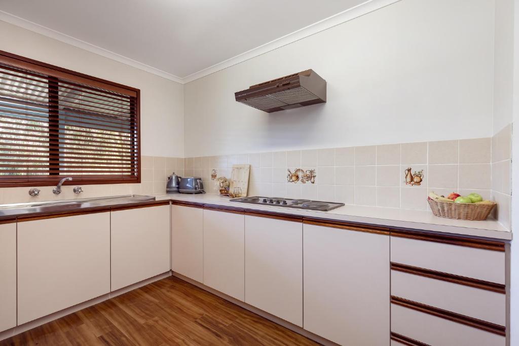 a kitchen with white cabinets and a sink at Roo With A View By Swan Bnb Management in Preston Beach