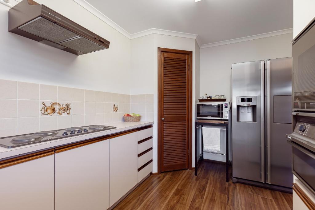 a kitchen with white cabinets and stainless steel appliances at Roo With A View By Swan Bnb Management in Preston Beach