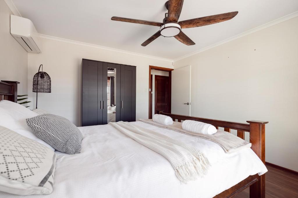 a bedroom with a white bed with a ceiling fan at Roo With A View By Swan Bnb Management in Preston Beach