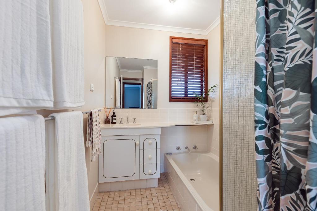 a bathroom with a tub and a sink and a mirror at Roo With A View By Swan Bnb Management in Preston Beach