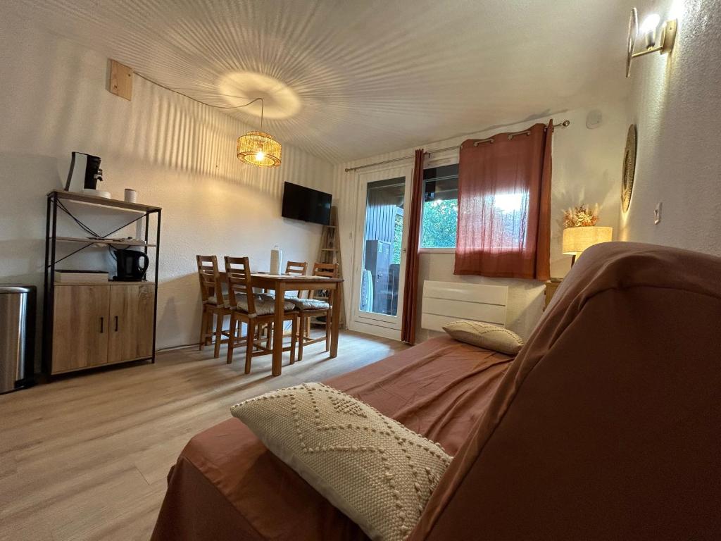 a bedroom with a bed and a table with chairs at Chalets du Village - Tily Home - Studio centre village in Villard-de-Lans