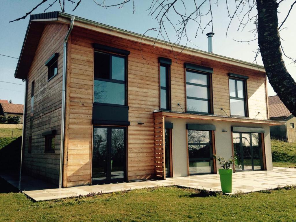 une maison avec des parois en bois et des fenêtres dans l'établissement L écrin verdoyant, à Jonzier-Épagny