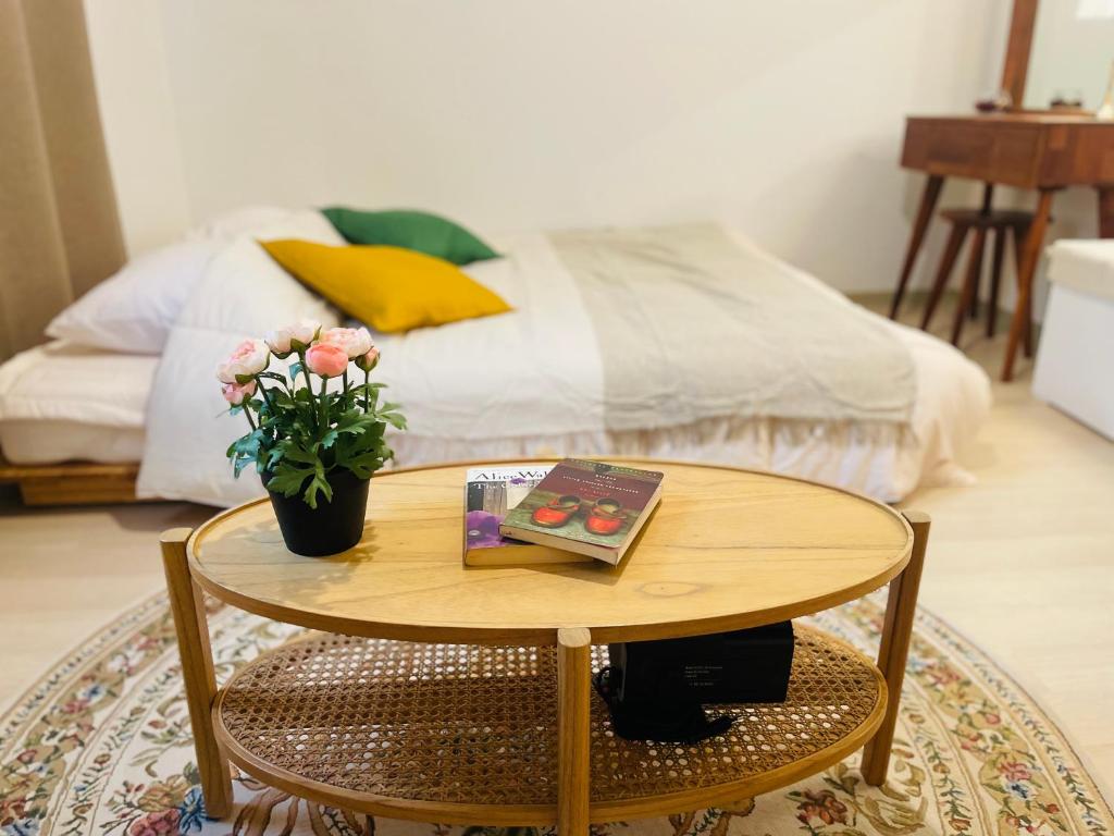 una mesa con un libro y flores junto a una cama en Sweet Breeze Stay Guesthouse, en Seúl