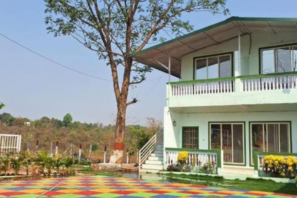 a house with a tree and a colorful carpet at Mikunj Farms Karjat in Karjat