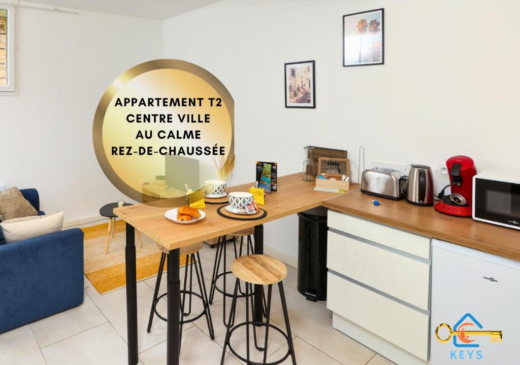 une cuisine avec une table et un panneau. dans l'établissement Le cocon centre ville au calme Oc Keys 34, à Castelnaudary