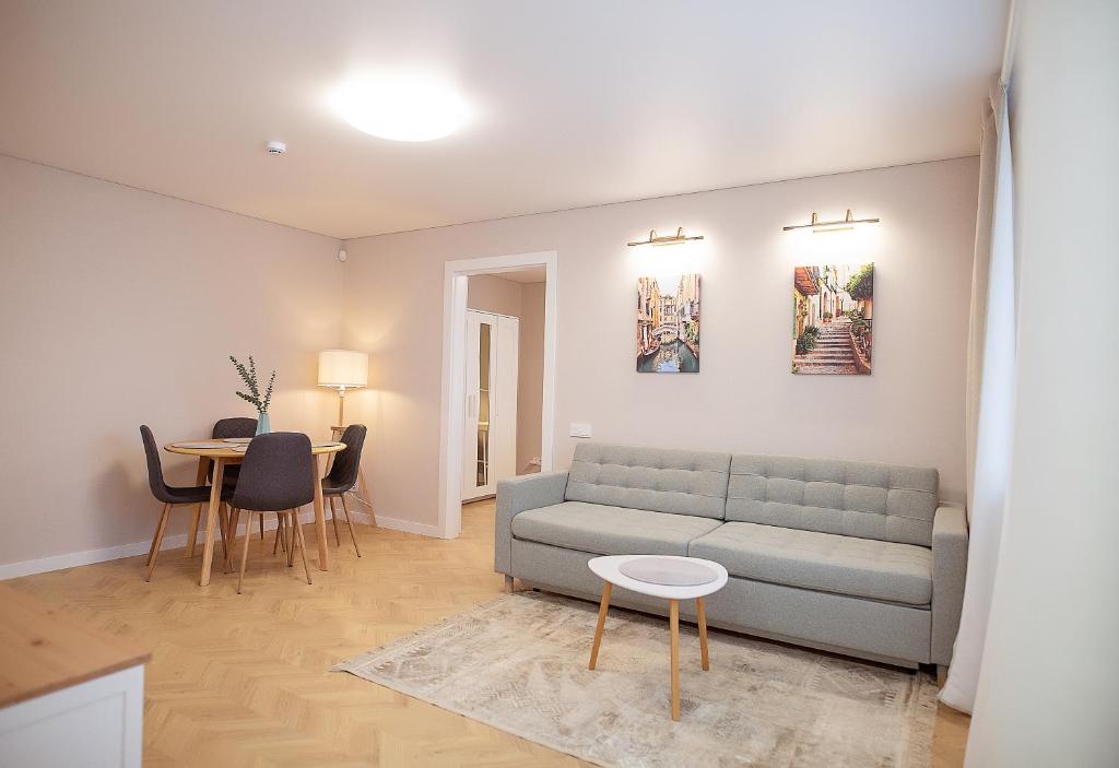 una sala de estar con un sofá y una mesa en Šviesus ir jaukus butas Šiaulių centre puiki vieta poilsiui #2, en Šiauliai