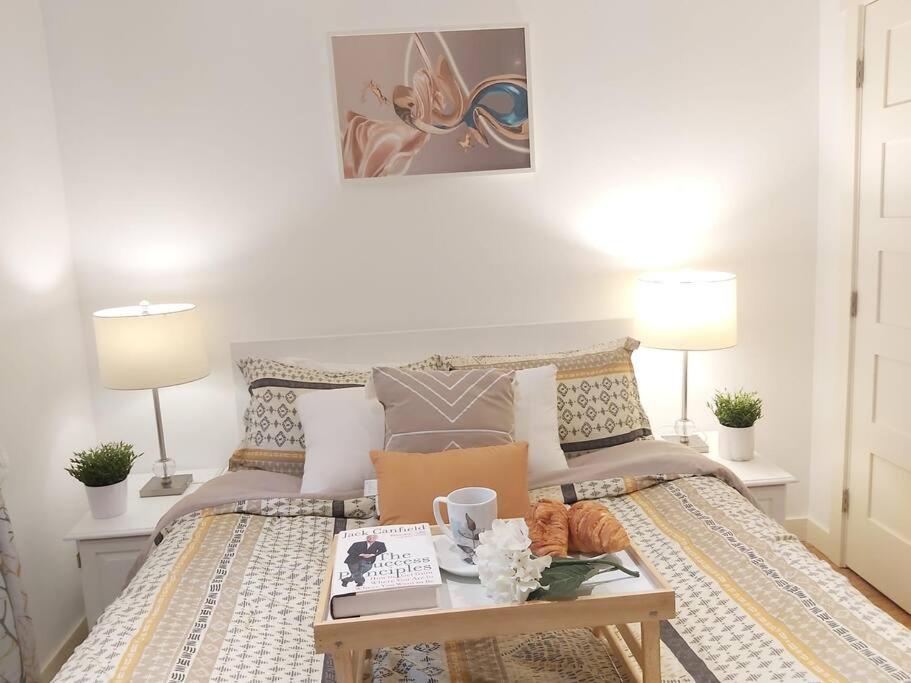 Un dormitorio con una cama con una mesa y dos lámparas. en Cozy suite, Free WIFI , Free Parking, en Calgary