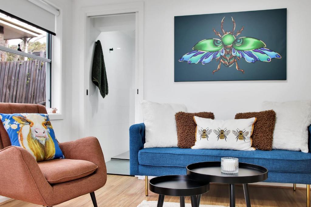 a living room with a blue couch and a table at Bee at Scenic I 2 BR Apartment near Geelong CBD in Geelong