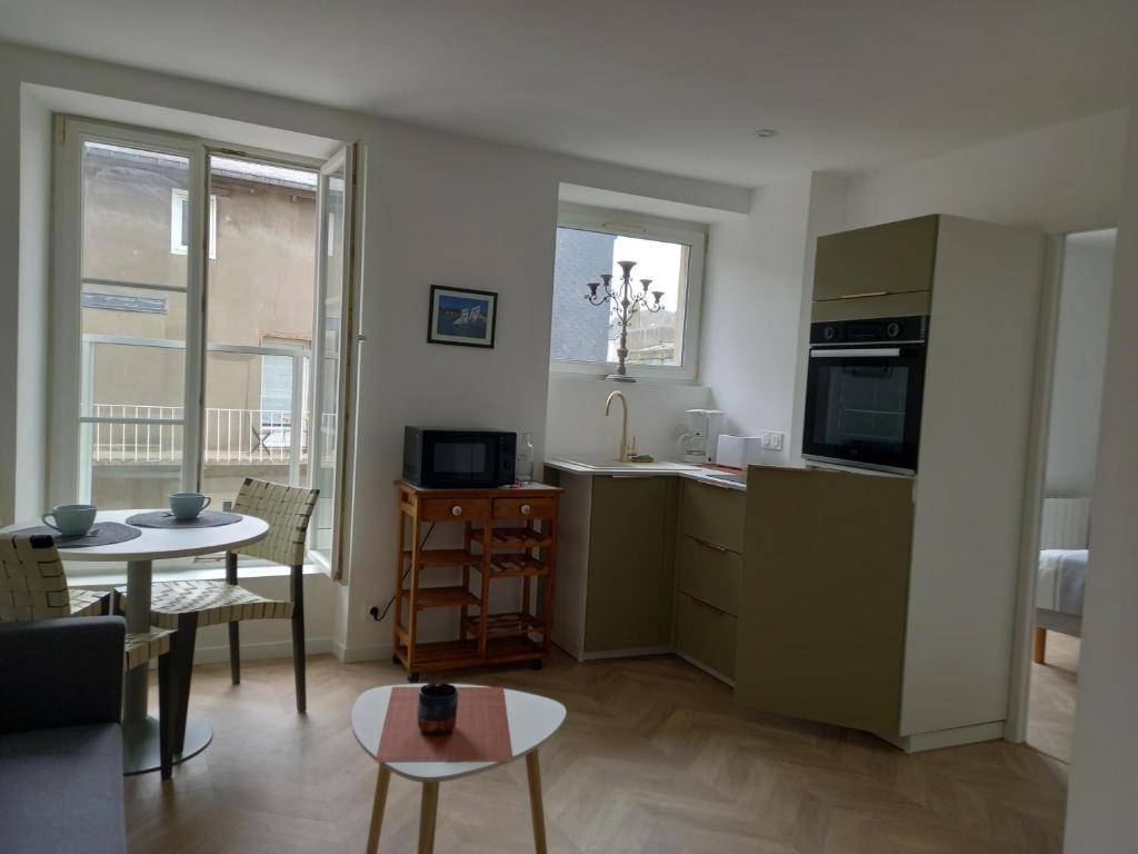 un salon avec une table et une cuisine dans l'établissement Plat Gousset, à Granville