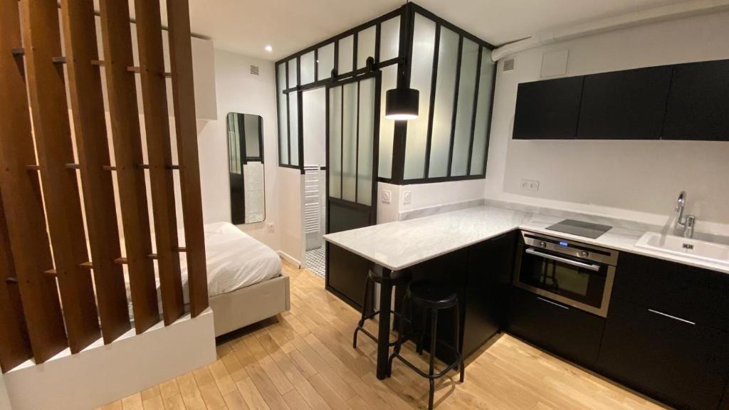 une cuisine avec un évier et un plan de travail dans l'établissement Joli studio au cœur de Paris, à Paris
