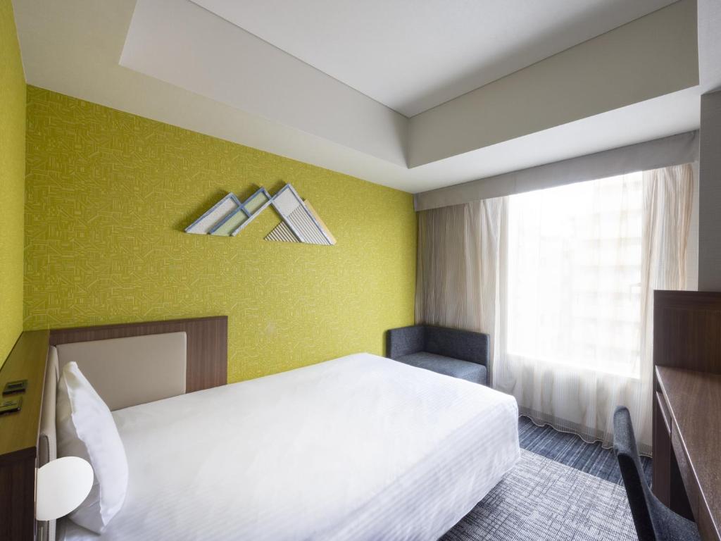 Postel nebo postele na pokoji v ubytování ibis Styles Kyoto Shijo