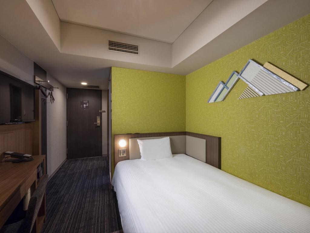 Postel nebo postele na pokoji v ubytování ibis Styles Kyoto Shijo