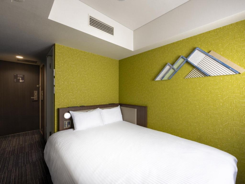 Postel nebo postele na pokoji v ubytování ibis Styles Kyoto Shijo