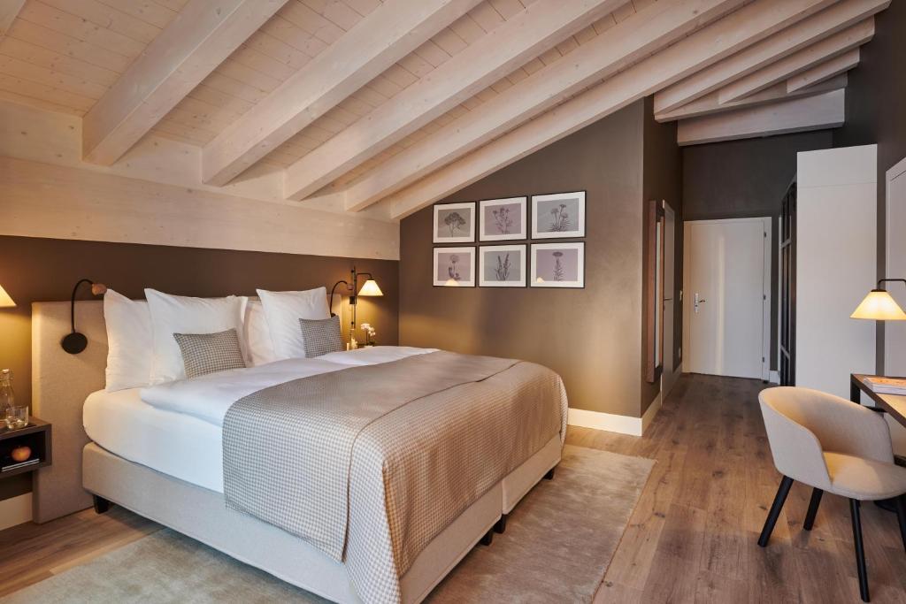 a bedroom with a bed and a desk and a chair at SCHLOSS Zermatt - CBD & Adaptogenic Spa and Sport Hotel in Zermatt