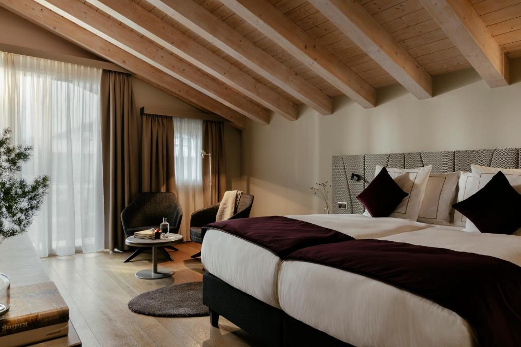a hotel room with a large bed and a table at SCHLOSS Zermatt - CBD & Adaptogenic Spa and Sport Hotel in Zermatt