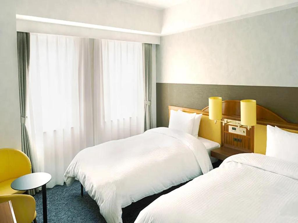 Postel nebo postele na pokoji v ubytování Prince Smart Inn Nagoya Sakae