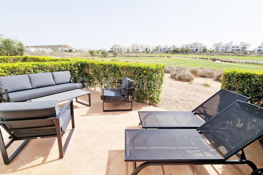 a patio with a couch and a table and chairs at Lovely Ground Floor 2 Bed with Golf Course Views in Sucina