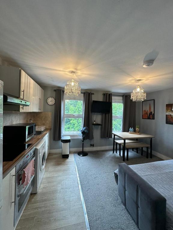 a kitchen and living room with a bed and a table at Cosy 2 BEDROOMS Apartment in London