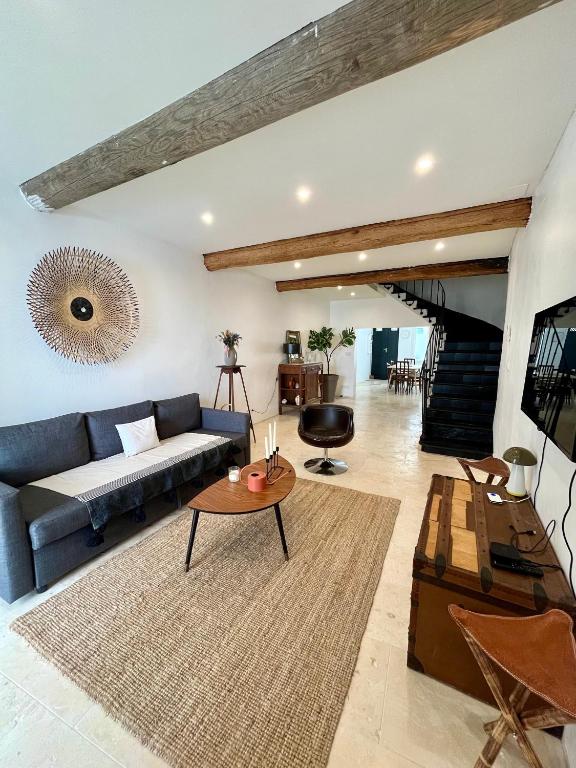 un salon avec un canapé bleu et une table dans l'établissement Maison de Village - Standing - Centre Historique, à Sigean