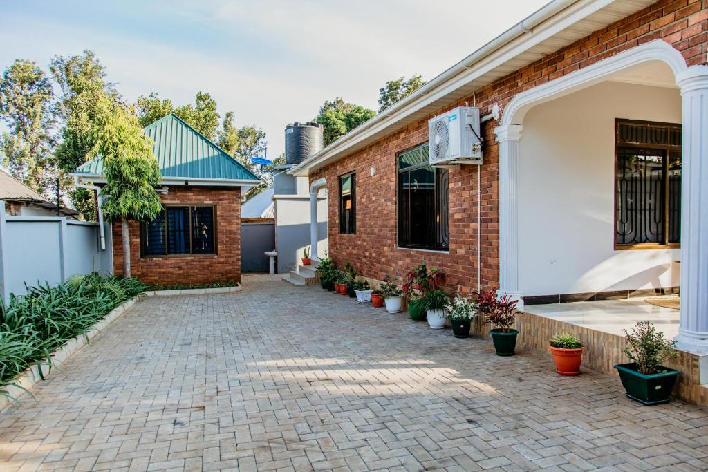 a brick driveway in front of a house with potted plants at Kwetu Maili6Homes 02 in Moshi