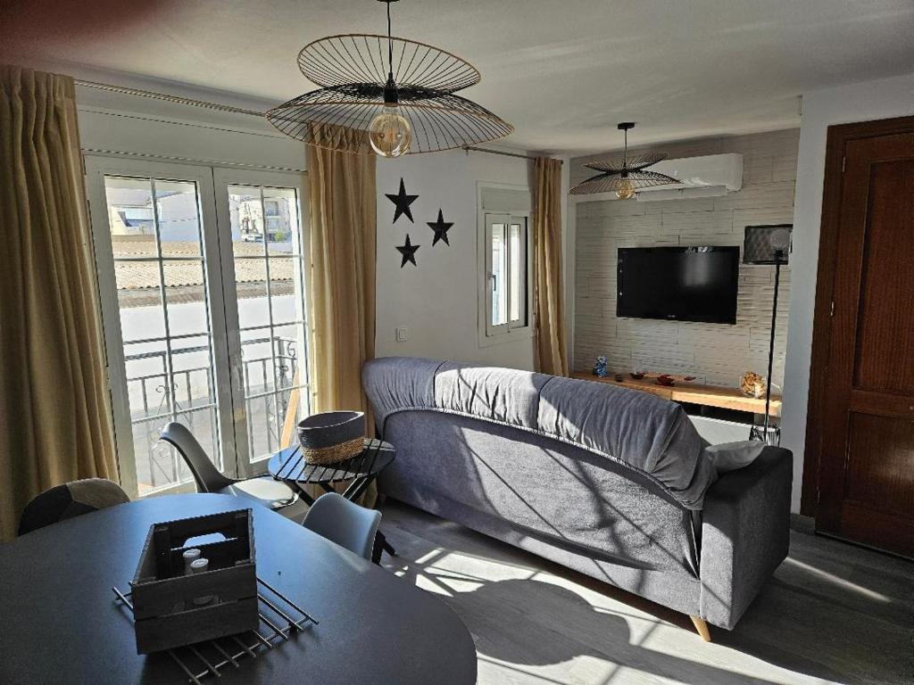 Una sala de estar con un sofá y un televisor. en Piso Ana appartement Cosy et moderne, Climatisé été, hiver, en Campillos