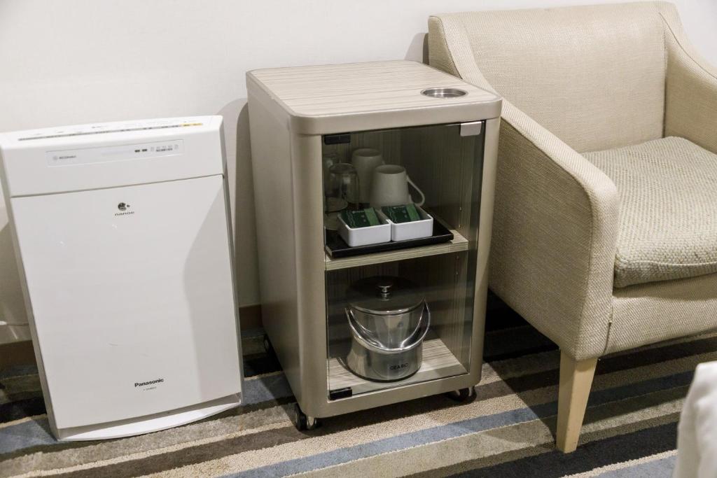 a small table next to a chair and a machine at Shinagawa Prince Hotel N Tower in Tokyo