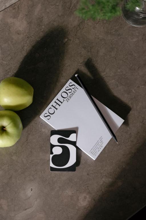 a piece of paper sitting next to two apples at SCHLOSS Zermatt - CBD & Adaptogenic Spa and Sport Hotel in Zermatt