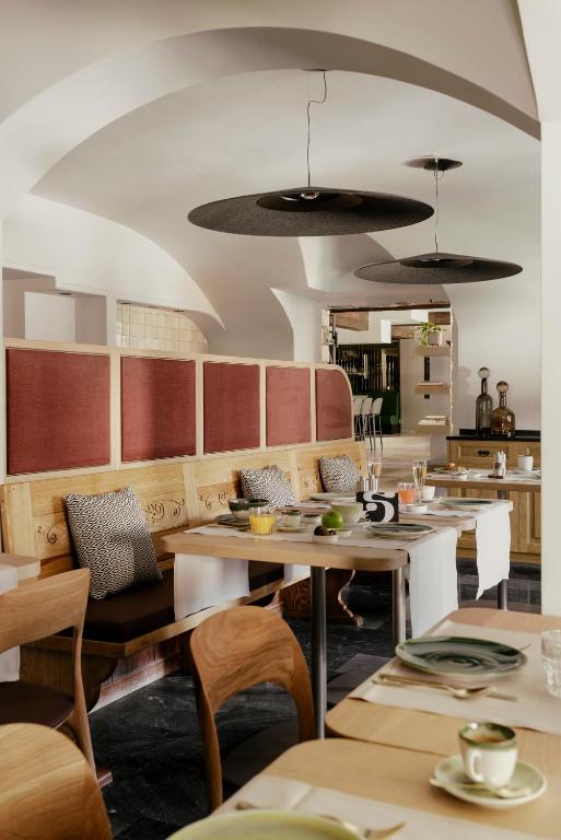 a restaurant with tables and chairs and a kitchen at SCHLOSS Zermatt - CBD & Adaptogenic Spa and Sport Hotel in Zermatt