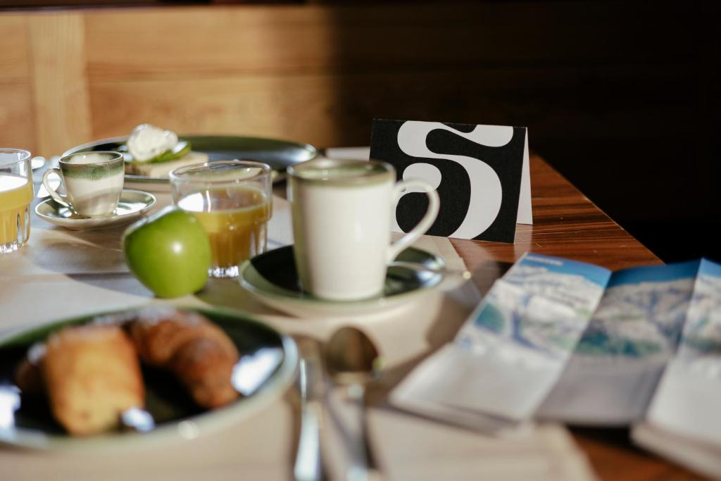 a table topped with cups of coffee and a bowl of food at SCHLOSS Zermatt - CBD & Adaptogenic Spa and Sport Hotel in Zermatt