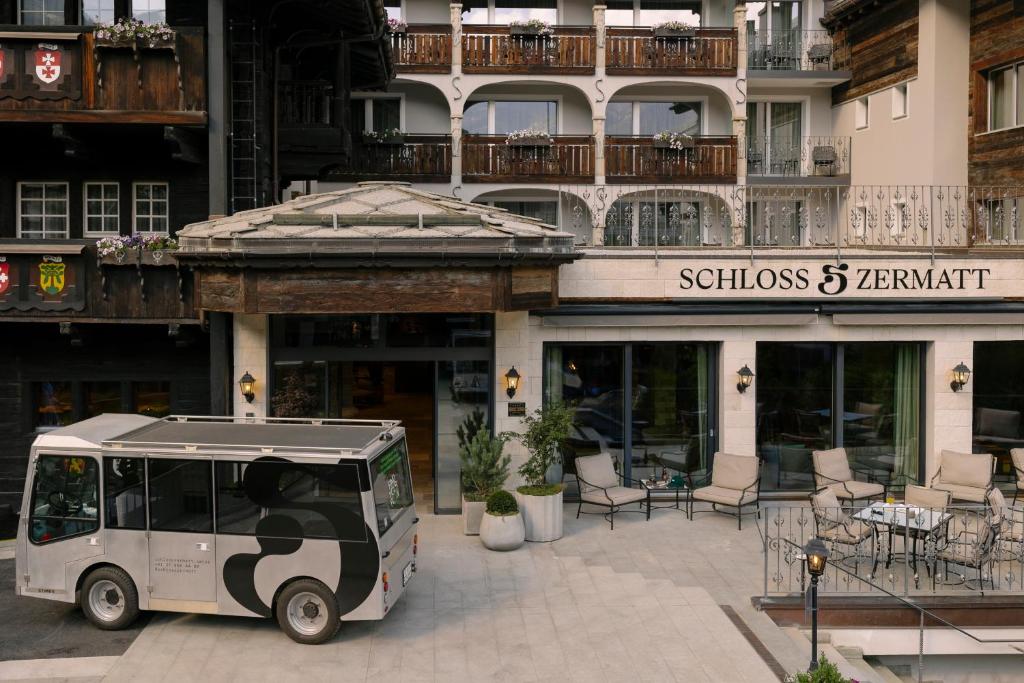 a golf cart parked in front of a building at SCHLOSS Zermatt - CBD & Adaptogenic Spa and Sport Hotel in Zermatt