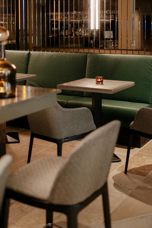 a restaurant with tables and chairs and a green couch at SCHLOSS Zermatt - CBD & Adaptogenic Spa and Sport Hotel in Zermatt