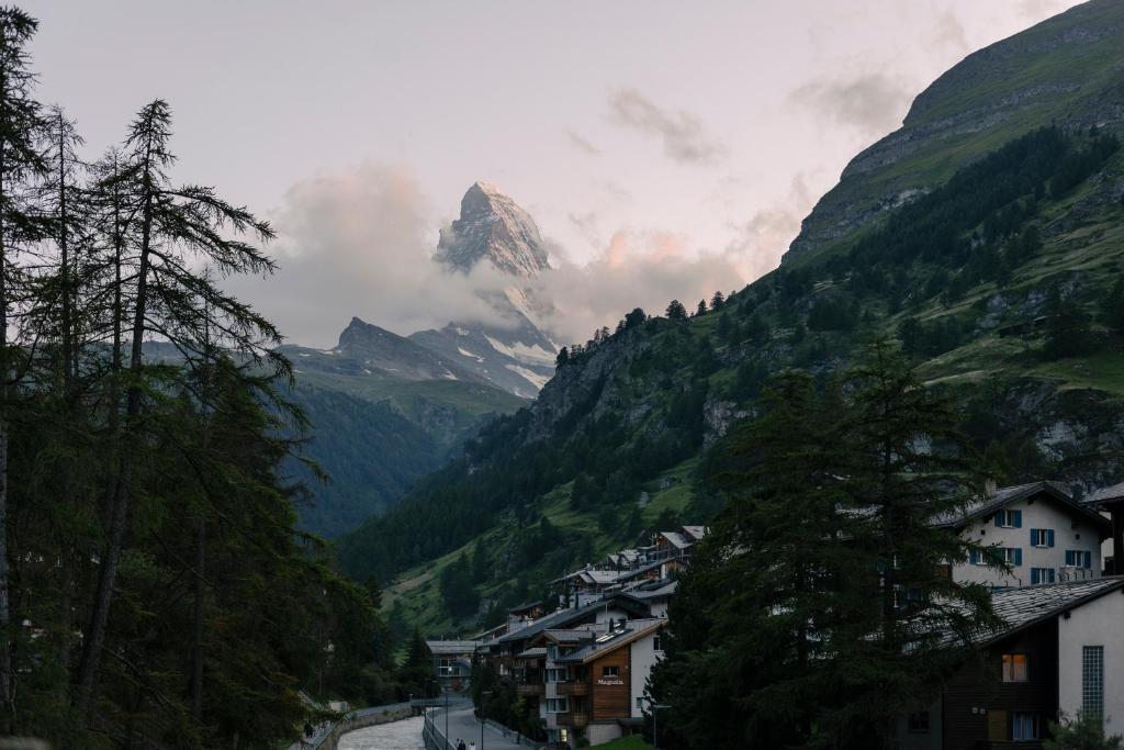 a mountain in the middle of a valley with houses at SCHLOSS Zermatt - CBD & Adaptogenic Spa and Sport Hotel in Zermatt