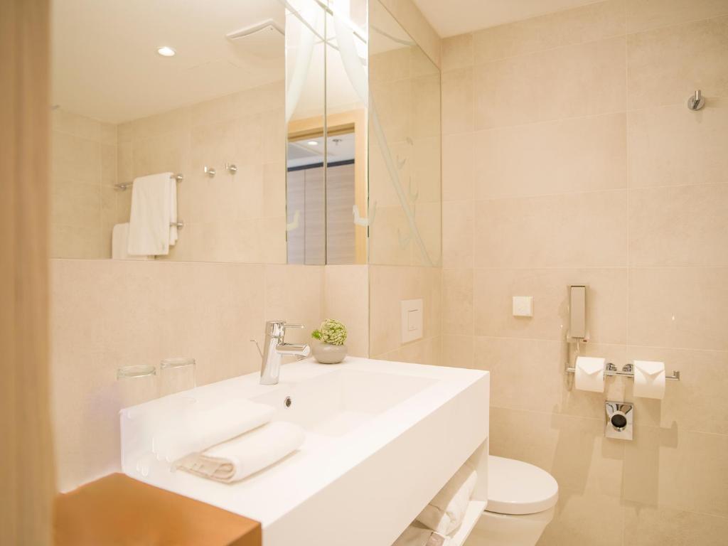 a bathroom with a white sink and a toilet at Hotel Kompas in Dubrovnik